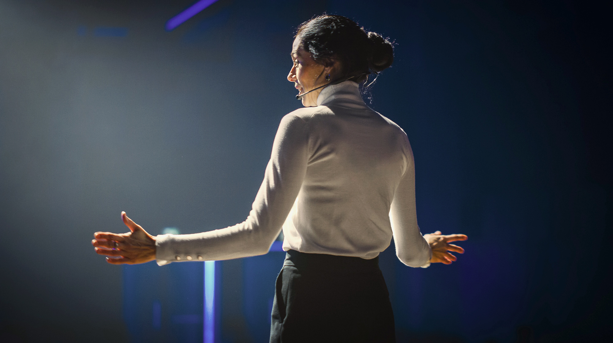 Professional presenting on stage demonstrating clear and structured presentation delivery
